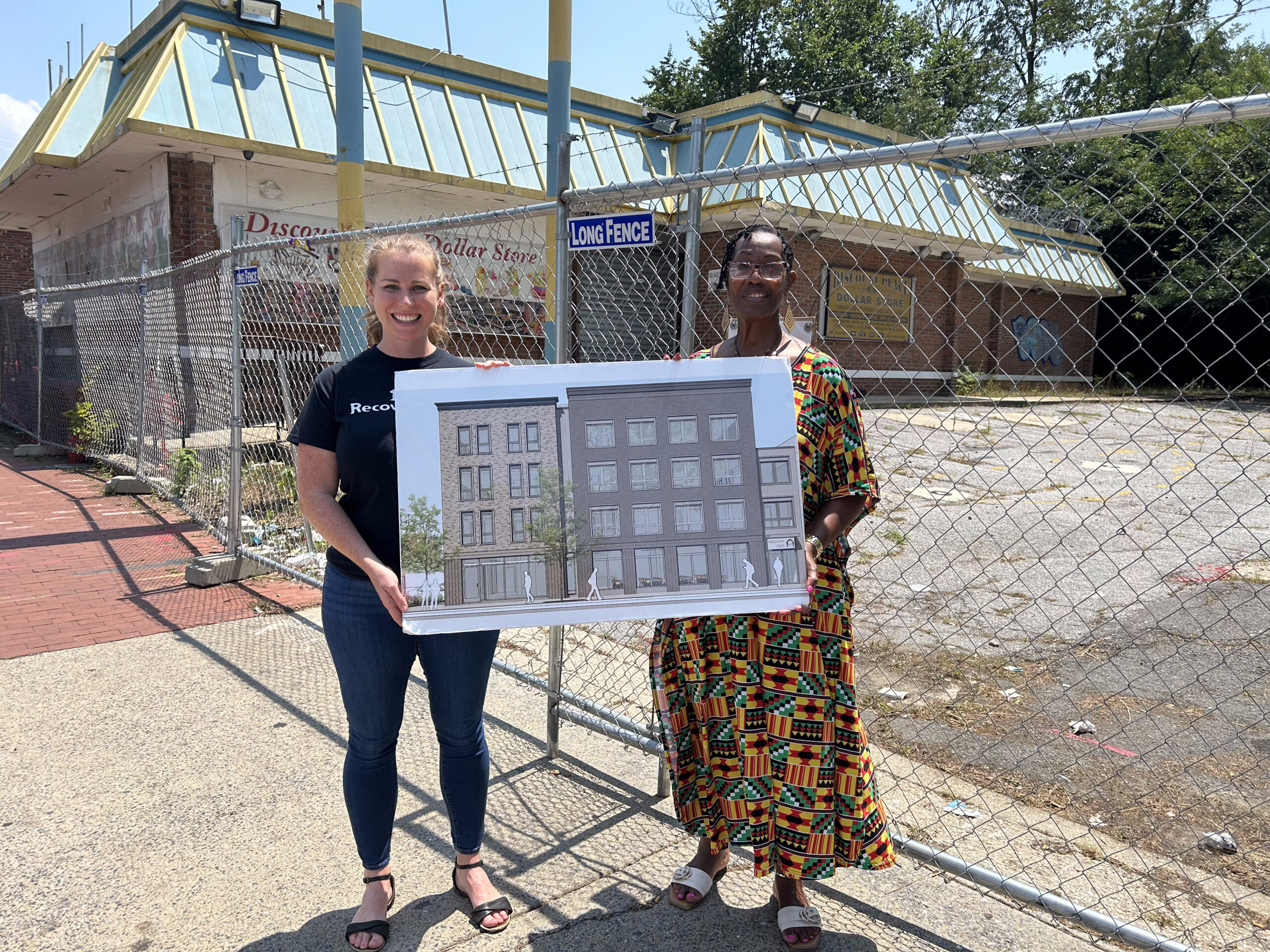 Recovery Cafe DC team holding the architectural rendering at the future site of Hope View Apartments and Recovery Cafe
